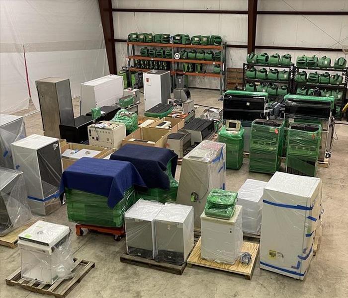 Image shows warehouse full of equipment that has been cleaned and processed, organized into bins.
