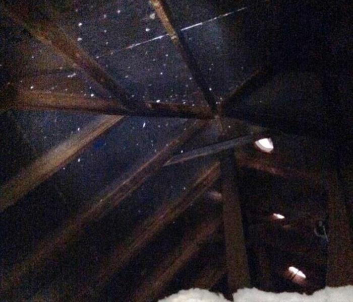 Images shows soot covering rafters in dark attic space.