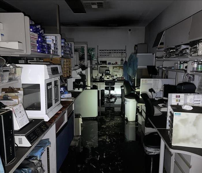 Image shows lab full of equipment covered with water and soot.